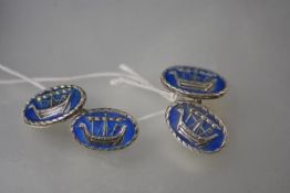 A pair of silver and enamel cufflinks after a design by Alexander Ritchie (Iona Silver),