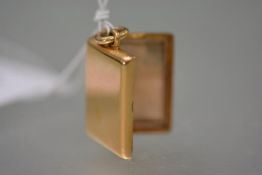 A late 19th/early 20th century rectangular gold locket, the suspension ring stamped "18", not