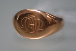 An 18ct gold signet ring, the oval plaque engraved with a monogram. 3.7 grams