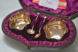 A cased pair of Victorian silver salts, each of open scalloped form, with spoons.