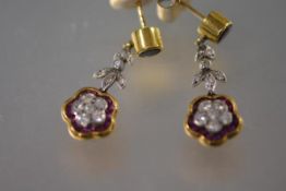 A pair of diamond and ruby drop earrings, each with round ruby stud in collet setting over a