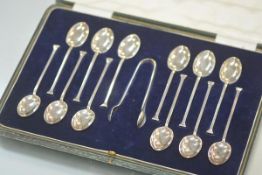 A cased set of twelve George V silver teaspoons with tongs, Sheffield 1923, the spoons with seal