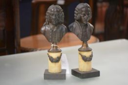 A pair of French 19th century bronze busts of Voltaire and Rousseau, each mounted on a marble column