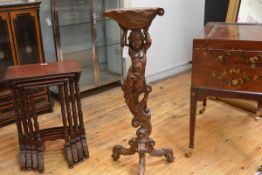A Continental walnut torchere, early 18th century, the top carved as a conch shell and with
