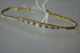 A diamond and emerald bracelet, set with seven graduated round brilliant-cut diamonds spaced by