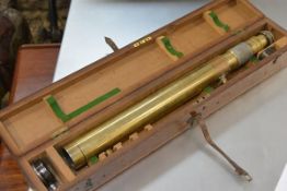 A large brass telescopic gun sight by Ross, London, numbered 63525, in a fitted wooden case.