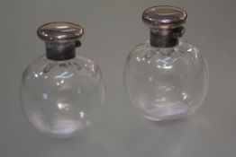 A pair of George V silver-topped scent bottles, hallmarked for London 1933, of globular form, with