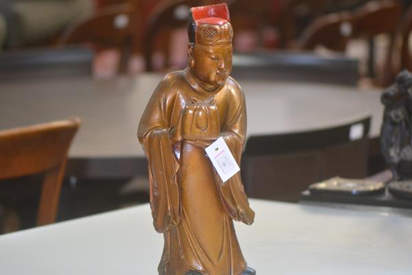 An Oriental carved, gilt and lacquered carving of a standing figure in formal robe holding a box.