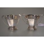 A George V cased silver sugar and cream, Hukin & Heath, Birmingham 1933, each of faceted oval