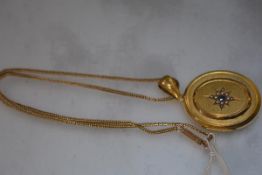 A Victorian gold (unmarked) locket, of oval form, the cover with raised panel centred by a