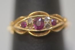 A ruby and diamond ring, early 20th century, centred by an oval cut ruby flanked by a pair of