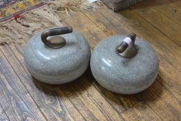 A pair of granite curling stones, c. 1900, each with brass-mounted ebonised wooden handle.