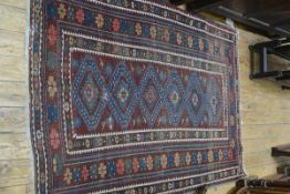 A Caucasian rug, the centre panel with six diamond shaped medallions enclosed within a multiple