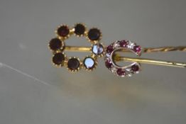 Two 19th century stick pins: the first formed as a horseshoe, set with alternating rubies and