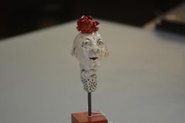 Claire Murray (British, Contemporary), Red Flower Man, glazed earthenware, mounted on a stand.