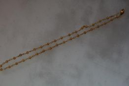 A Nigerian yellow metal (unmarked) fancy link chain necklace, composed of pierced spheres on an oval