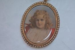 A portrait miniature of a young girl, c. 1900, oval, watercolour on ivory, in a yellow metal mount