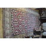 A large Caucasian hall rug, the central panel with interlocking medallions enclosed within a