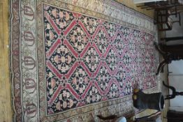 A large Caucasian hall rug, the central panel with interlocking medallions enclosed within a