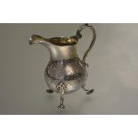 An 18th century silver cream jug, of baluster form, raised on shaped pad feet, with later 19th