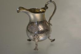 An 18th century silver cream jug, of baluster form, raised on shaped pad feet, with later 19th