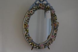 A Continental floral encrusted porcelain mirror, late 19th century, the oval plate within a