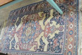 A Caucasian rug, the central diamond enclosed within a figural, bird and multiple flower border,