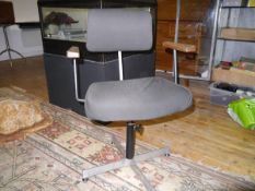 A 1960's revolving desk chair, with cloth back and adjustable seat, wooden arms, raised on cruciform