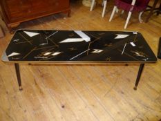 A 1950's coffee table, the rectangular glazed top with period geometric designs on splayed