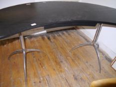 A modernist ebonised oak desk, the kidney-shaped top above a frieze drawer and raised on tubular