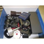 A box containing a collection of camera equipment to include light meters, filters and lenses