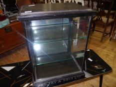 A glazed ebonised shop display cabinet c. 1900, inscribed J.S. Fry & Sons Ltd., with mirrored rear