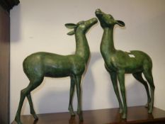 A pair of green patinated metal garden sculptures of deer. 57cm