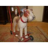 A vintage Tri-ang push-along fox terrier, c. 1960, the composition body with glass eyes and red