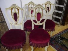 A set of four gilt-highlighted cream-painted chairs, each with shield-shaped back and raised on