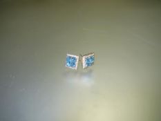 A pair of blue topaz and diamond cluster earrings, each set with four square-cut topaz within a band