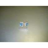 A pair of blue topaz and diamond cluster earrings, each set with four square-cut topaz within a band