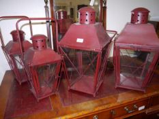Two pairs of red painted lanterns. Larger pair (excluding handle) 55cm