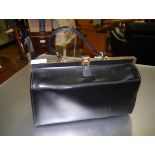 A large black handbag of Gladstone type, with gilt-brass fastener. Width 38.5cm
