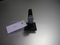 A striking blue topaz and diamond dress ring, mounted with a pair of pear-cut topaz amidst round