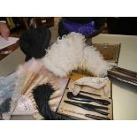 A group of lady's vintage accessories including two feather fans, a lace fan, a black bonnet,