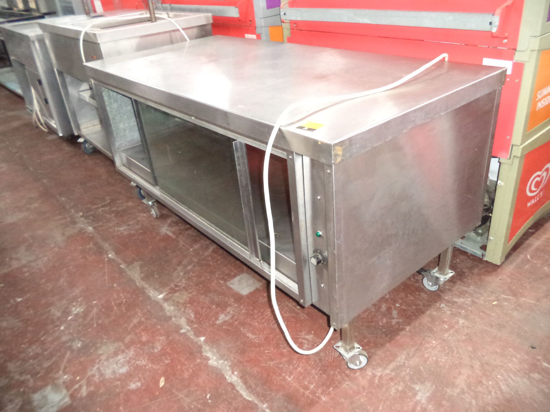 Large stainless steel mobile warming unit, with sliding glass doors on one side but no doors on