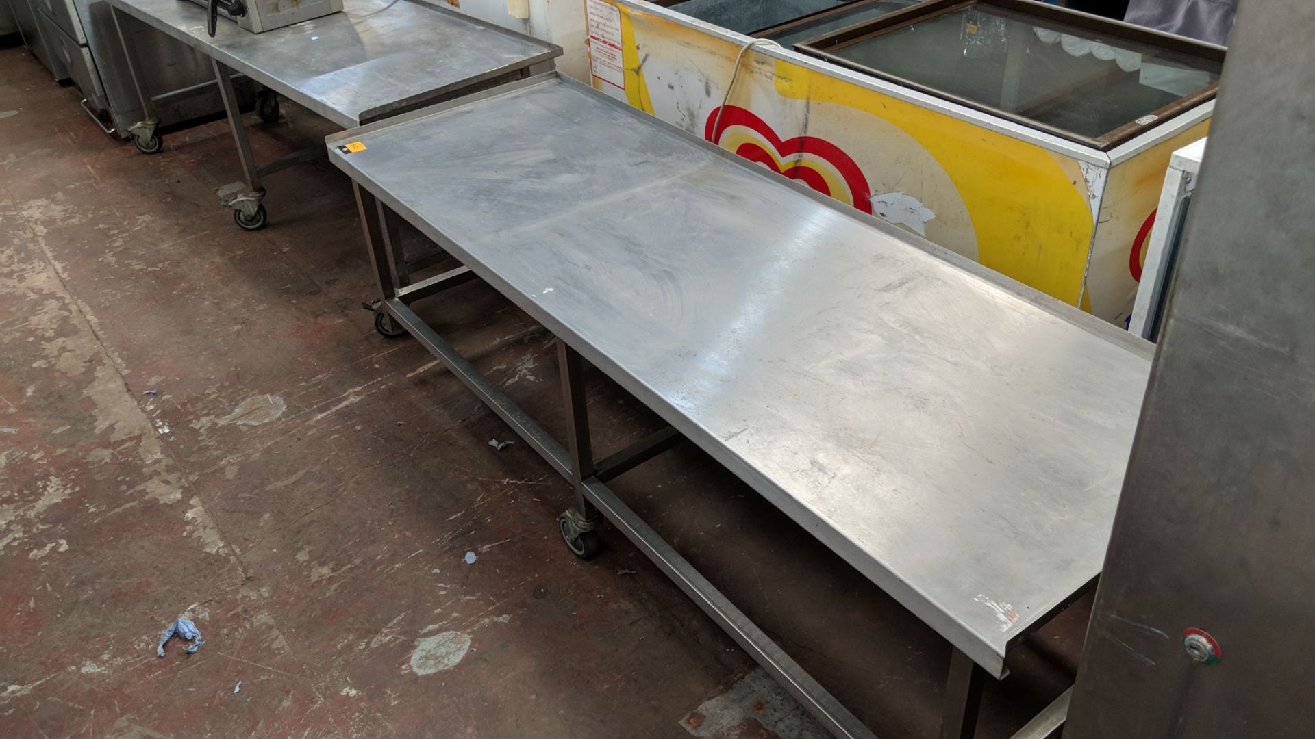 2 off long low mobile stainless steel tables, each circa 1850mm long IMPORTANT: Please remember