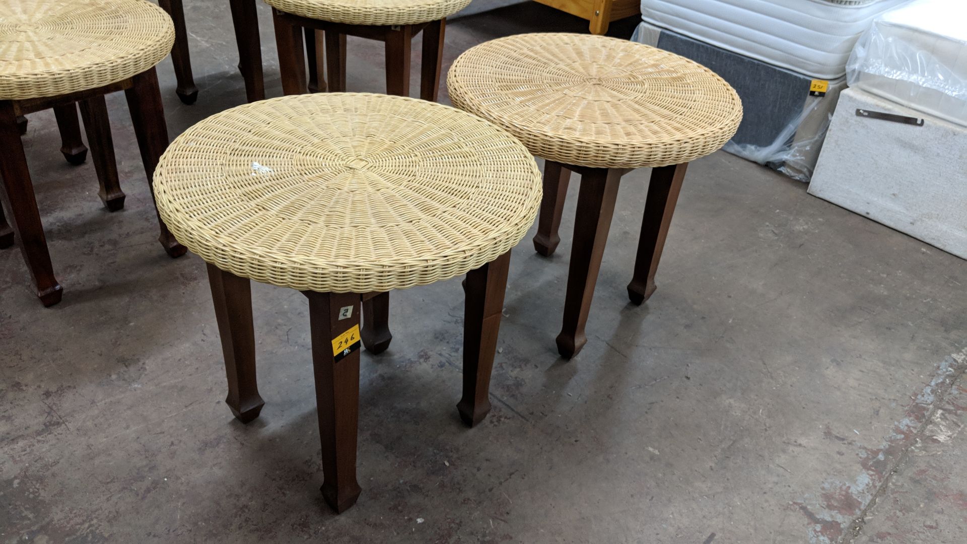 Pair of round tables with wooden legs & wicker type top, each table having a diameter of