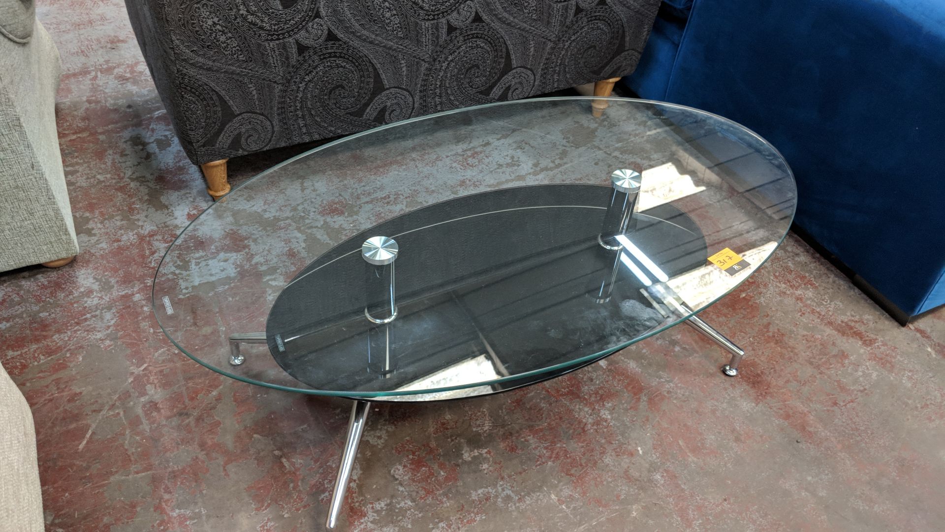 Oval glass twin tier table, top shelf measuring approximately 1200mm x 700mm IMPORTANT: Please