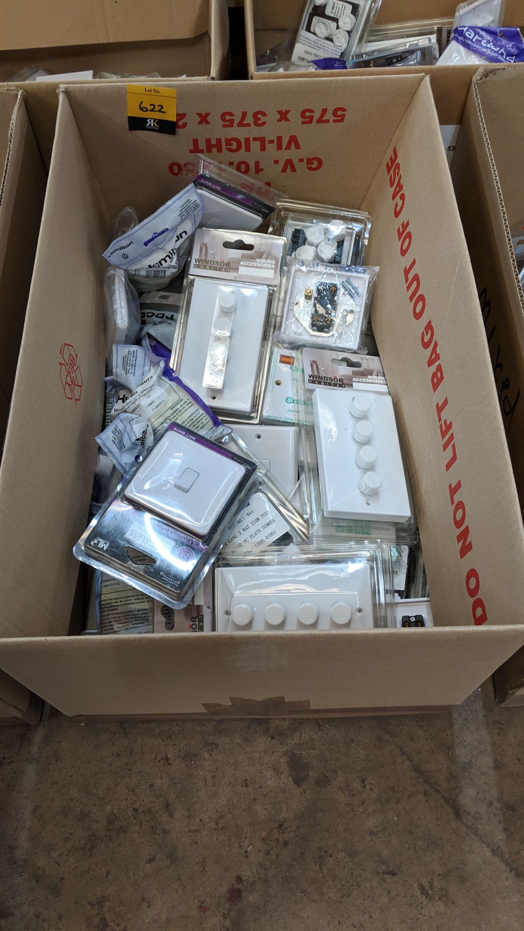 The contents of a box of assorted moulded white plastic dimmer & regular light switches & related