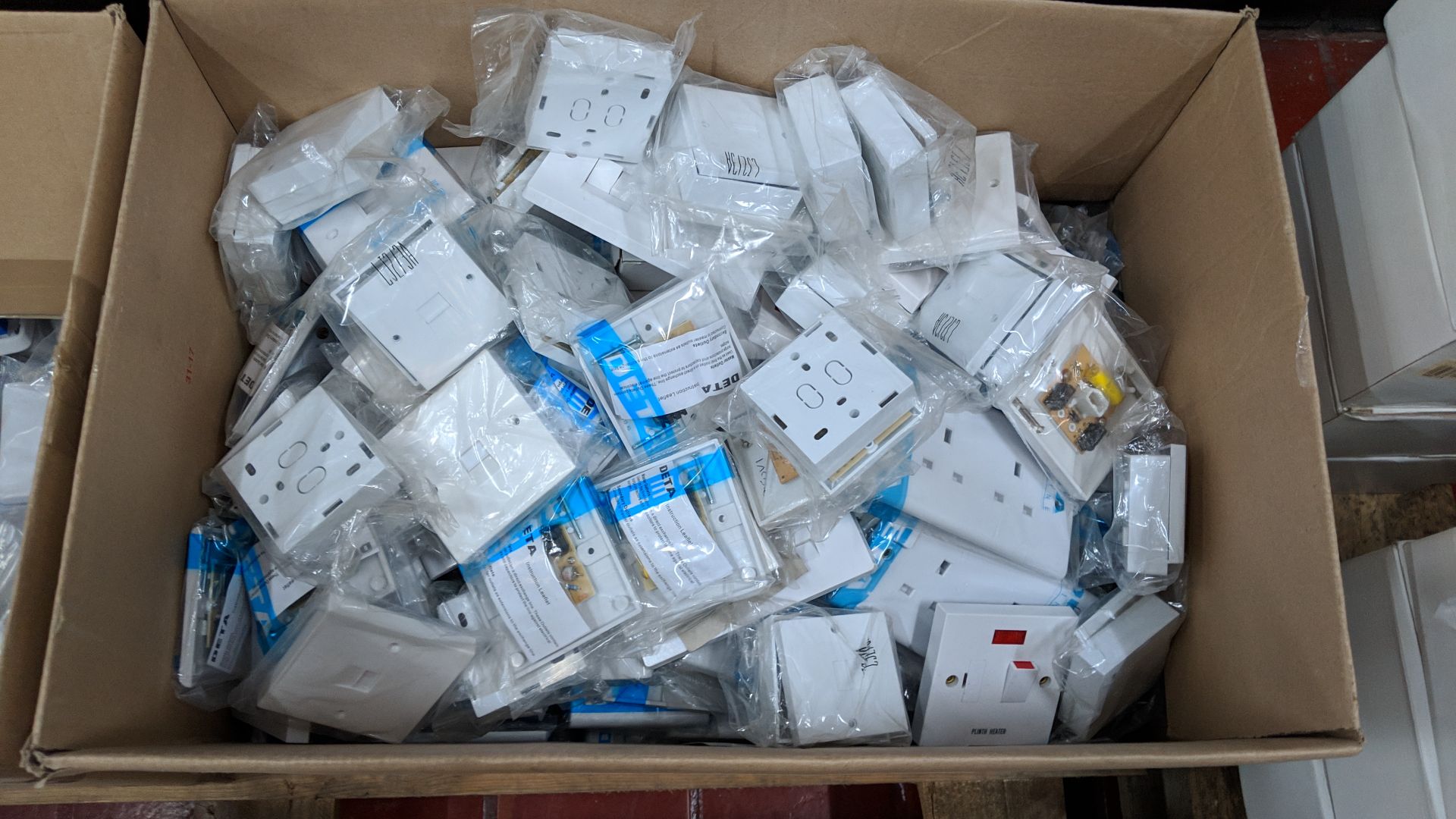 The contents of 4 crates/boxes of assorted fused switches, aerial sockets, plug sockets, pattress - Image 7 of 10