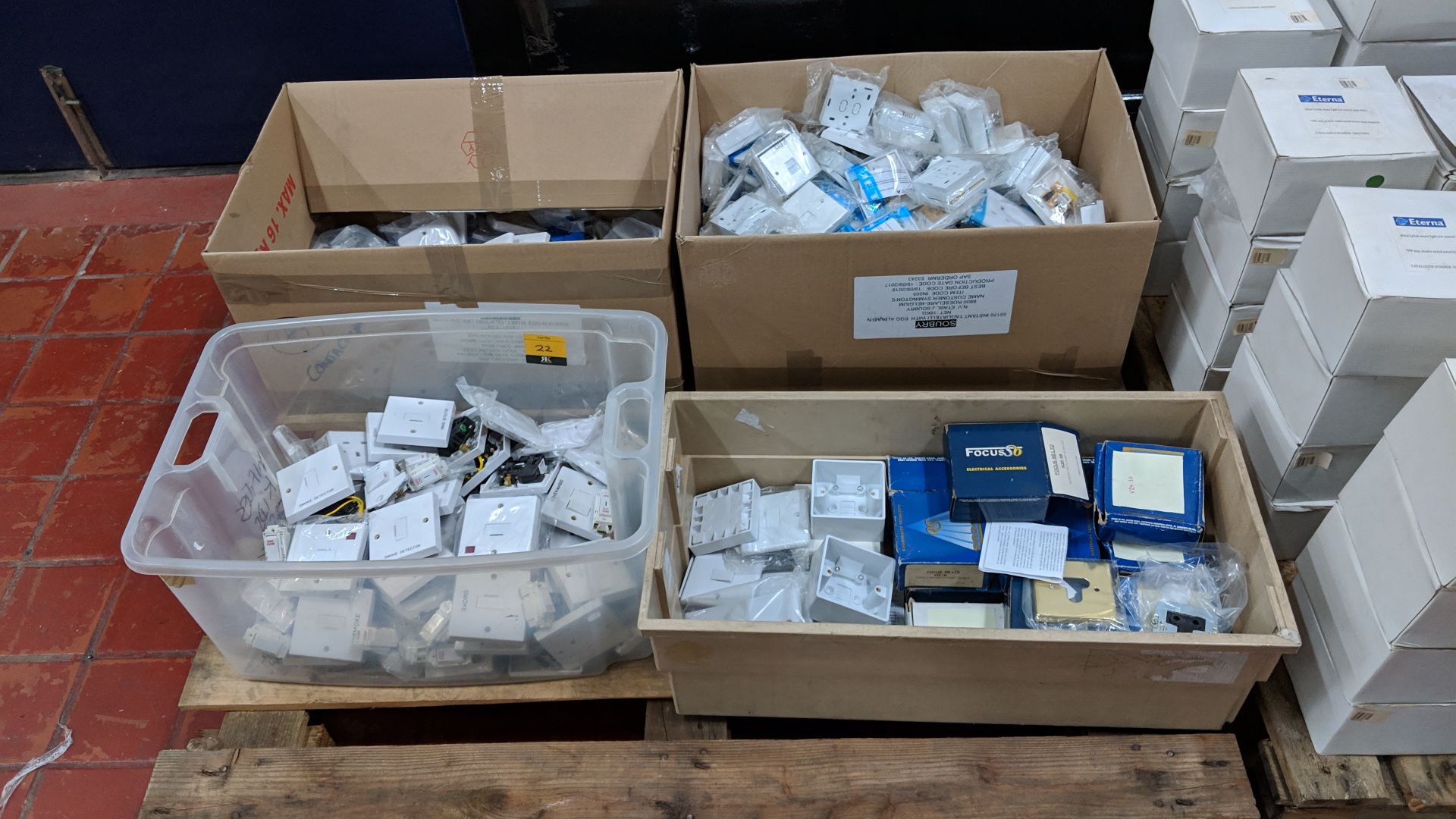 The contents of 4 crates/boxes of assorted fused switches, aerial sockets, plug sockets, pattress