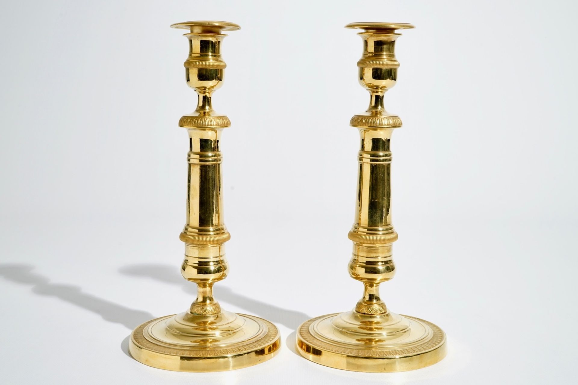 A pair of gilt bronze Empire candlesticks, France, 19th C. H.: 27,5 cm We have more lots available