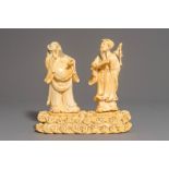 A Chinese carved ivory group of two figures on a ground, 18/19th C.